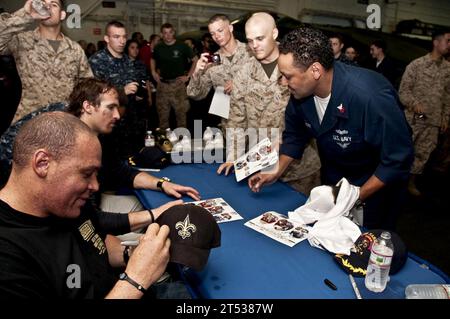 1003288936G-226 DJIBOUTI (28. März 2010) New Orleans Saints Tight End Billy Miller, Left, und New Orleans Saints Quarterback Drew Brees unterzeichnen Autogramme für Seeleute und Marines in der Hangarbucht des amphibischen Angriffsschiffs USS Nassau (LHA 4). Miller und Brees besuchten Nassau im Rahmen einer USO-Tour. Nassau ist die Kommandoplattform der Nassau Amphibious Ready Group, die Operationen zur Gefahrenabwehr im Seeverkehr und zur Zusammenarbeit im Bereich der Theatersicherheit im Zuständigkeitsbereich der 5. US-Flotte unterstützt. Stockfoto