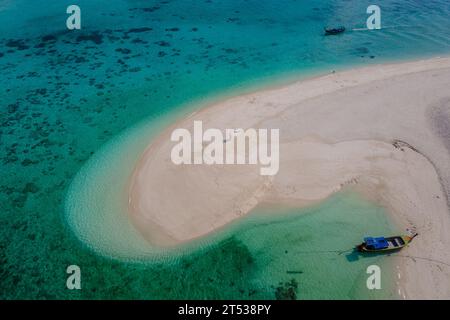 Ein paar Männer und Frauen auf einer weißen Sandbank im Ozean von Koh Lipe Island im Süden Thailands. Stockfoto