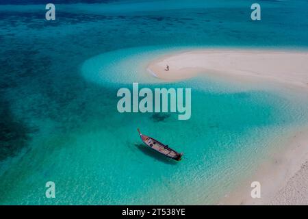 Ein paar Männer und Frauen an einer weißen Sandbank im Ozean von Koh Lipe Island im Süden Thailands, mit türkisfarbenem Ozean Stockfoto