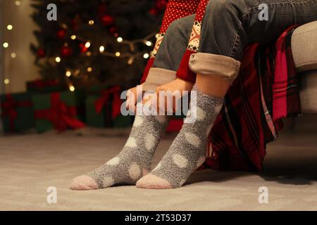 Frau in warmen Socken zu Hause am Heiligabend Stockfoto