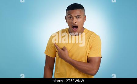 Zeigen, Schocken und Porträt eines Mannes in einem Studio mit Mockup für Marketing, Werbung oder Werbung. Überraschung, Wow und junger Mann mit einer Show Stockfoto