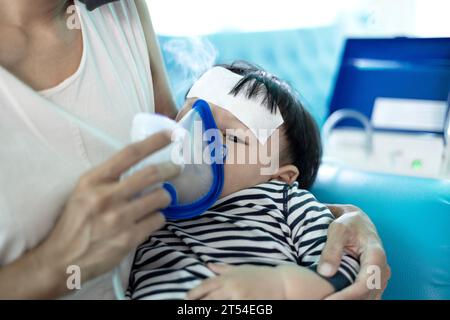 Kleiner Junge mit Einatmung. Mutter Hilft Dem Kleinen Sohn, Den Vernebler Während Der Inhalation Zu Verwenden. Stockfoto