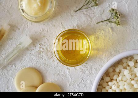 Ätherisches Öl mit Sheabutter, Bienenwachs-Pellets und Kakaobutter auf weißem Hintergrund, Draufsicht Stockfoto