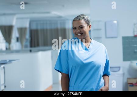 Porträt einer glücklichen, birassischen Ärztin, die im Krankenhaus Peelings trägt, Kopierraum Stockfoto