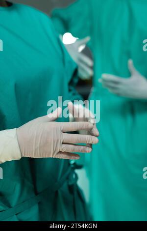 Mittelteil diverser Chirurgen mit Operationsmantel im Operationssaal im Krankenhaus Stockfoto