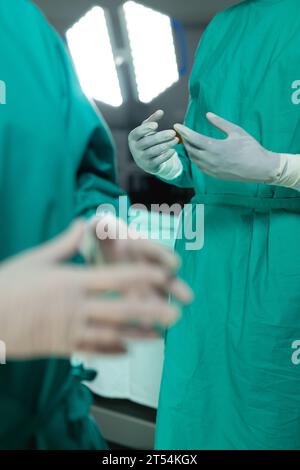 Mittelteil diverser Chirurgen mit Operationsmantel im Operationssaal im Krankenhaus Stockfoto