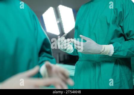 Mittelteil diverser Chirurgen mit Operationsmantel im Operationssaal im Krankenhaus Stockfoto