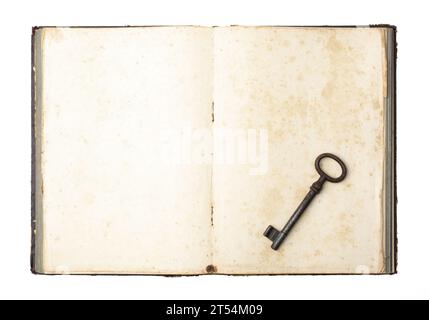 Der antike Schlüssel auf dem alten Buch. Symbol des Geheimnisses. Altes antikes Buch mit Schlüsseln auf leerem Blatt. Stockfoto