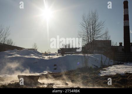 Rohrfabrik. Entsorgung von Abfällen auf das Feld. Ein rostiges Rohr ragt aus dem Boden. Ableitung des Wassers aus der Kesselstation. Stockfoto