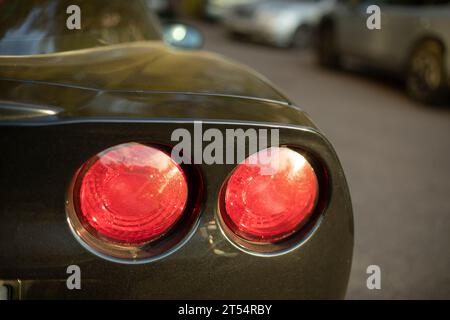 Details eines Sportwagens. Runde Signalleuchten an Fahrzeugen. Rote Scheinwerfer. Maschinenbau Stockfoto