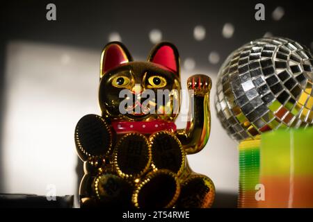 Katzenmaskottchen. Die Katze, Die Glück Bringt. Spielzeug im Regal. Ein Symbol für Erfolg. Goldene Figur. Stockfoto