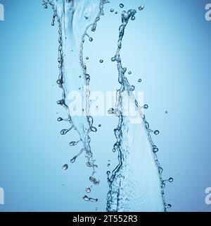 Wasserspritzer vor blauem Hintergrund Stockfoto