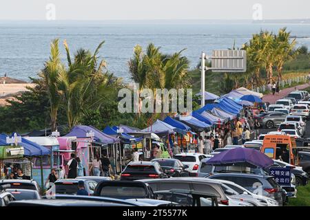 Peking, China. Oktober 2023. Dieses am 4. Oktober 2023 aufgenommene Foto zeigt Fahrzeuge für selbstfahrende Touren und einen Open-Air-Markt entlang einer malerischen Küstenstraße in Wenchang, südchinesischer Provinz Hainan. Quelle: Pu Xiaoxu/Xinhua/Alamy Live News Stockfoto