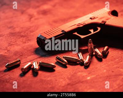 Handfeuerwaffe mit Munition auf dunklem Hintergrund. 9-mm-Pistole, Militärwaffe und ein Haufen Munition am Metalltisch. Stockfoto