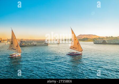 Traditionelle Felukenboote auf dem Nil in Assuan. Herrlicher Blick auf den Nil bei Sonnenuntergang. Assuan, Ägypten – 19. Oktober 2023 Stockfoto