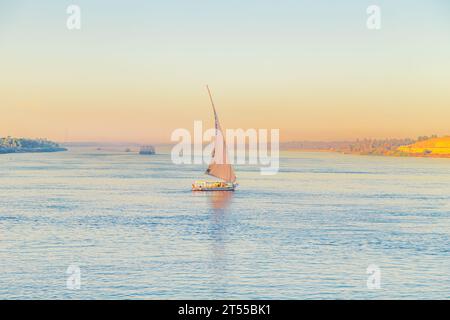 Traditionelles Felukenboot auf dem Nil. Herrliche Aussicht auf den Nil bei Sonnenuntergang. Assuan, Ägypten - 19. Oktober 2023. Stockfoto
