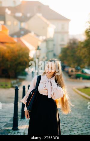 Eine junge Frau spaziert durch das sonnige Prag Stockfoto