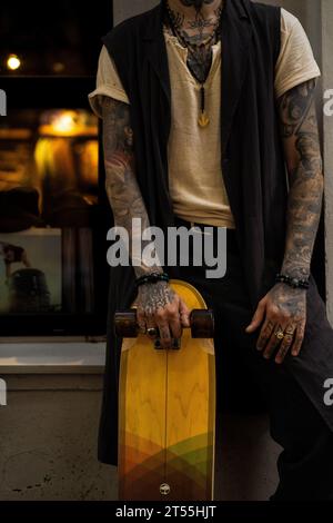 Mann mit Skateboard, tätowierte Hand. Stockfoto