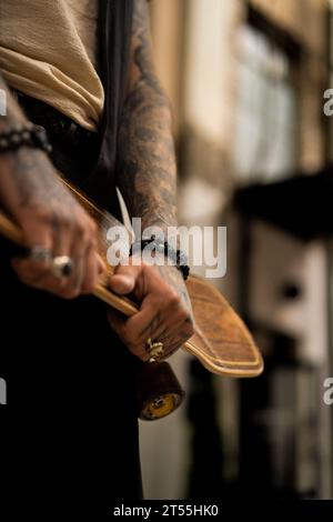 Mann mit Skateboard, tätowierte Hand. Stockfoto