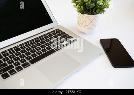 Laptop-Computer auf dem Schreibtisch mit Telefon Stockfoto