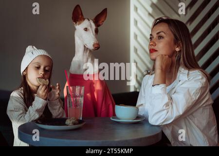 Mutter mit Tochter und Hund in einem Café. Haustiere sind willkommen. Stockfoto