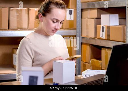 Junge Startup-Unternehmerin, die mit Smartphone zu Hause, Online-Geschäft, E-Commerce und Lieferkonzept arbeitet Stockfoto