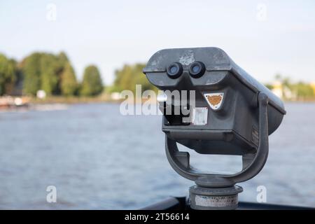 Münzbinokularbetrachter am Rande eines Flusses Stockfoto