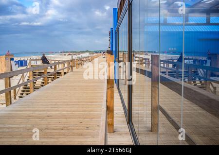 Restaurant Glas und Holzsteg am Strand. Strand Monte Gordo, Vila Real de Santo Antonio, Portugal Stockfoto