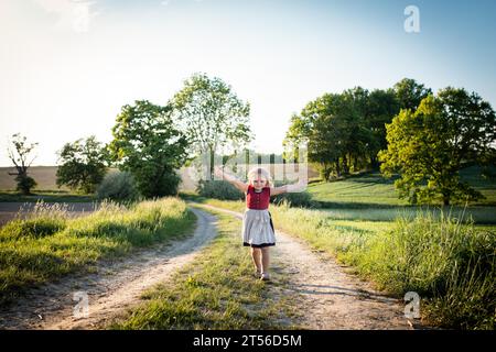 Kind singt während eines Spaziergangs auf einer Landstraße, Altomünster, Oberbayern, Bayern, Deutschland Stockfoto