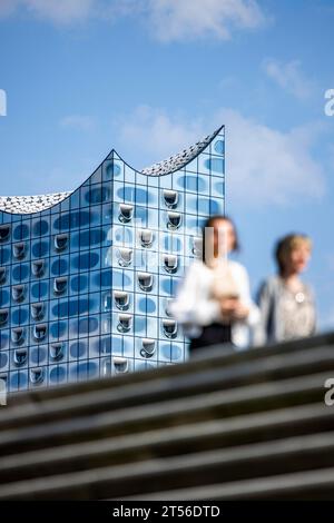 Silhouetten von Menschen auf der Hafenpromenade vor der Elbphilharmonie, Hamburg Stockfoto