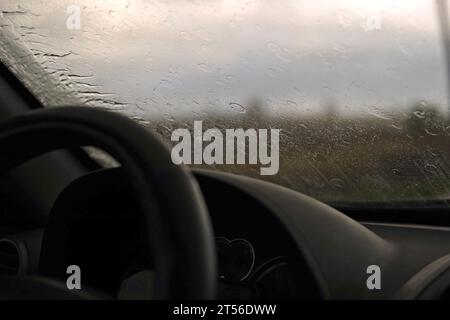 Extremes Fahren bei starkem Regenwetter. Selektiver Fokus. POV der Windschutzscheibe des Autos. Gefährliche Fahrt auf nassem Asphalt. Schlechte Sichtbarkeit. Bewegliche Windschutzscheibe Stockfoto