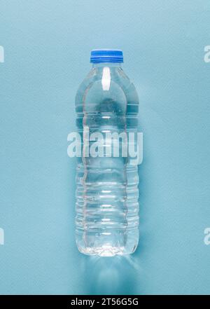 Wasserflasche aus Kunststoff auf blauem isoliertem Hintergrund Stockfoto