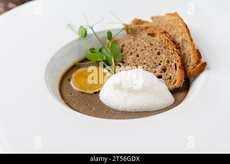 Crostini Fegatini auf weißem Porzellanteller auf Holztisch Stockfoto