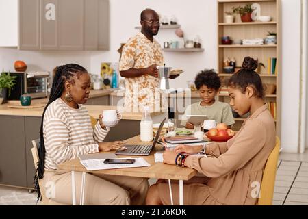 Familie frühstückt und bereitet sich auf den neuen Tag in Schule und Büro vor Stockfoto