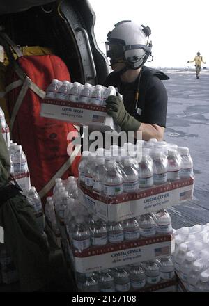 US Navy ein Flugbesatzungsschiff Sailor an Bord des amphibischen Mehrzweckschiffs USS Wasp (LHD 1) lädt Wasser in Flaschen auf eine MH-60S Seahawk, die der Helicopter Sea Combat Squadron (HSC) 28.jpg zugewiesen ist Stockfoto