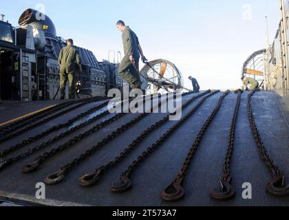 Besatzungsmitglieder der US Navy eines Landungsfahrzeugs mit Luftpolsterung reinigen das Schiff und verstauen Halteketten, nachdem sie Fahrzeuge und Ausrüstung von Elementen der 31 MEU, die an Bord der USS Harpers Ferry.jpg eingestiegen waren, verlassen hatten Stockfoto