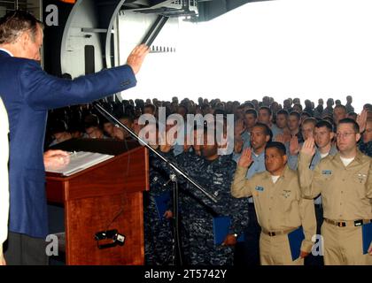 Der ehemalige US-Navy-Präsident George H.W. Bush liest den Eid der Einberufung während einer Massenerneuerung und einer frockenden Zeremonie in der Hangarbucht des Flugzeugträgers USS George H.W. Bush (CVN 77).jpg Stockfoto