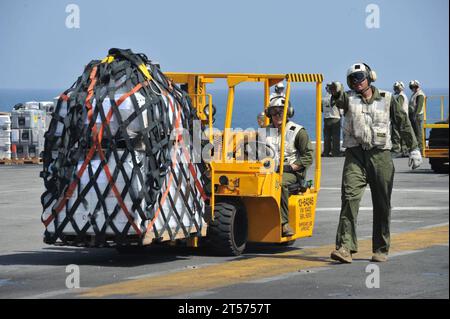 Die US Navy Marines aus der Kampffracht, die der 11. Marine Expeditionary Unit (11. MEU) zugeordnet ist, transportieren Vorräte über das Flugdeck abo.jpg Stockfoto