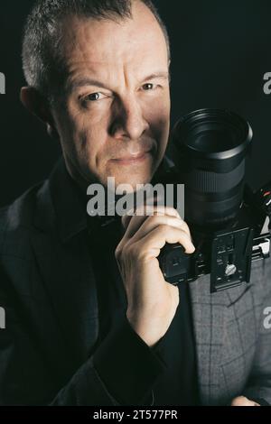 Fotograf, Videograf im Studio im Anzug Foto. Stockfoto