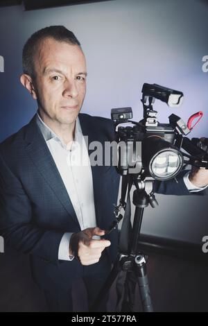 Fotograf, Videograf im Studio im Anzug Foto. Stockfoto