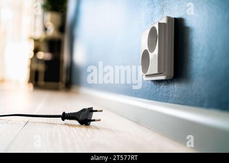 Steckdose und Steckdose. Elektrostecker. Kabel von der Wand abgezogen. Kabel und Kabel. Strom aus. Energieverbrauch, Krise oder Einsparung. Stockfoto