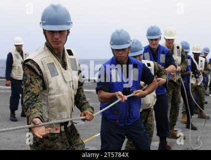 US Navy-Seeleute und Marines, die dem vorwärtsgerichteten amphibischen Transportschiff USS Denver (LPD 9) zugeteilt sind, fahren auf der a.jpg herum Stockfoto