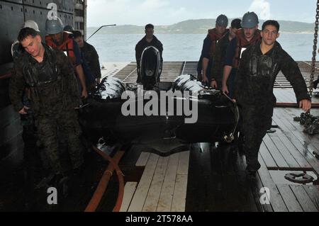 US Navy-Seeleute und Marines holen ein Kampfkautschuk-Raiding-Boot auf dem Brunnendeck des vorwärtsgerichteten amphibischen Angriffs sh.jpg Stockfoto