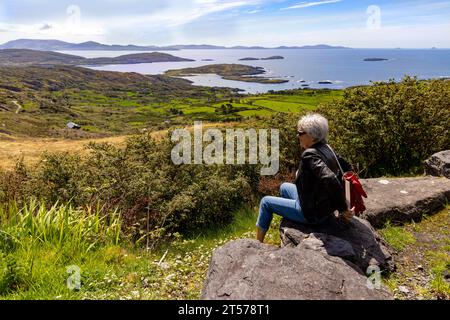 Touristen bewundern die malerische Küste entlang der Kenmare Bay am Ring of Kerry, in der Nähe des Scariff Inn, Caherdaniel, County Kerry, Irland Stockfoto