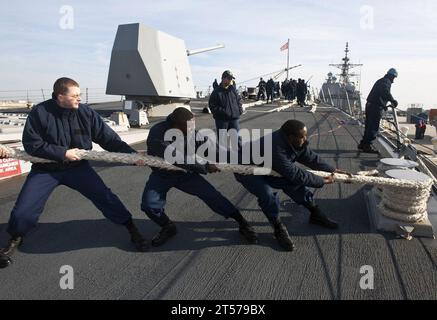 US-Navy-Seeleute bewegen sich um eine Festmacherlinie am Vorläufer des Raketenzerstörers der Arleigh-Burke-Klasse USS James E. Willi.jpg Stockfoto