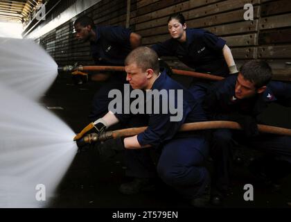 US Navy-Seeleute bemannen einen Feuerwehrschlauch während eines Absturzes und Bergung drill.jpg Stockfoto