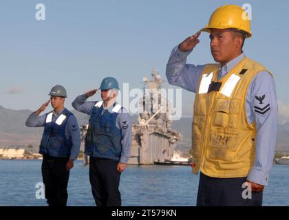 Die US-Navy-Seeleute des auf Pearl Harbor basierenden Raketenzerstörers USS Paul Hamilton (DDG 60) grüßen während der Morgenfarben, als das amphibische Angriffsschiff der Tarawa-Klasse USS Peleliu (LHA 5) auf pierside to.jpg fährt Stockfoto