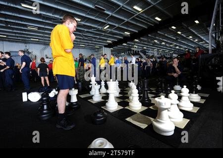 Die US-Navy-Seeleute spielen ein großes Schachspiel in Hangar Bay 2 während eines Picknicks am Strand an Bord des Flugzeugs car.jpg der Nimitz-Klasse Stockfoto