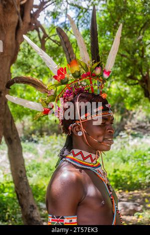 SOUTH HORR, KENIA – 12. FEBRUAR 2020: Junger Mann des Samburu-Stammes, der nach seiner Beschneidungszeremonie einen farbenfrohen Kopfschmuck aus Straußenfedern trägt. Stockfoto