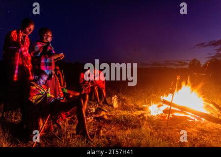 MASAI MARA, KENIA - 20. FEBRUAR 2020: Masai-Männer mit Lagerfeuer, Kenia Stockfoto